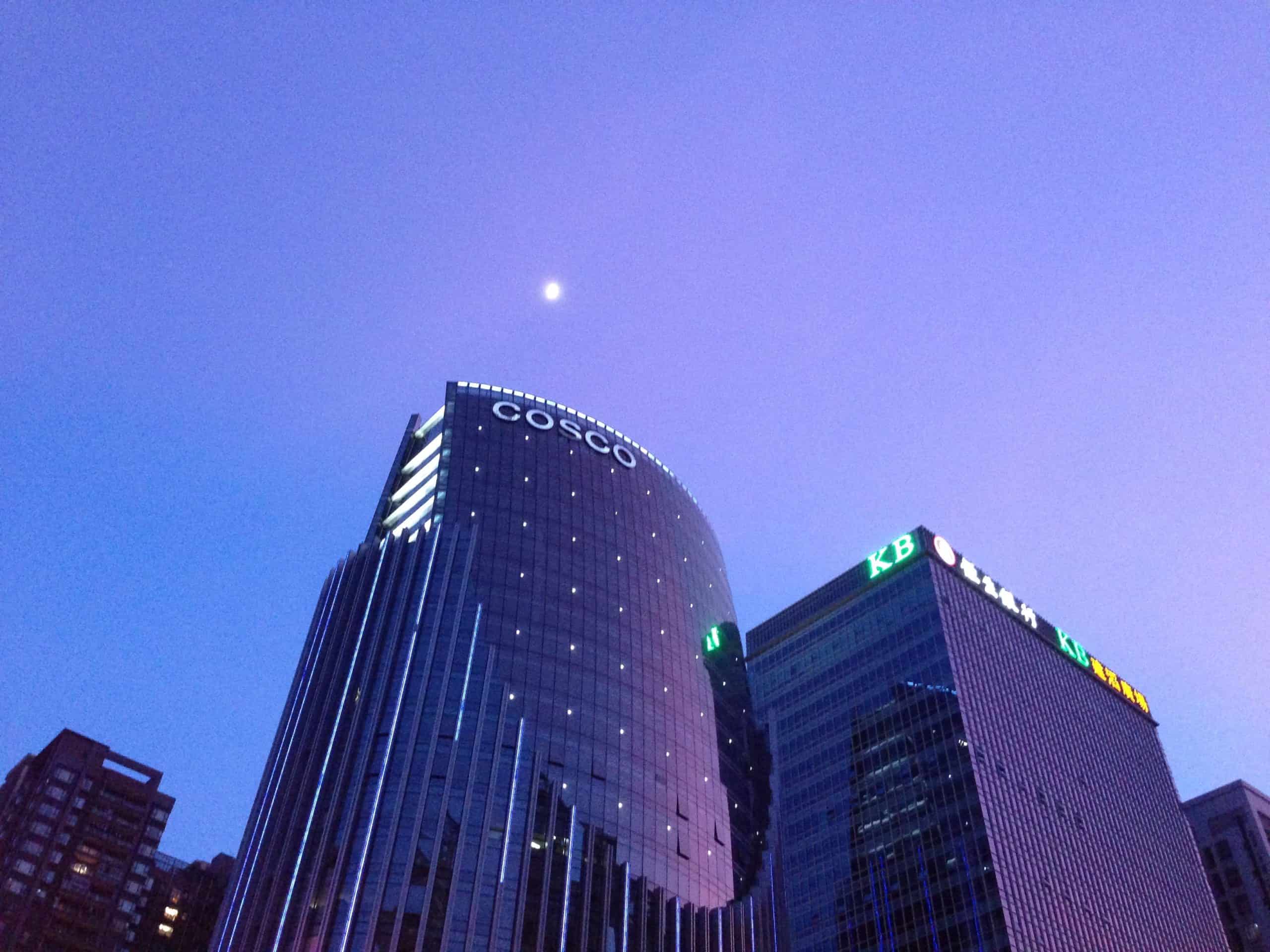 The moon shining brightly over the skyscrapers in Zhujiang New Town, Guangzhou, China.