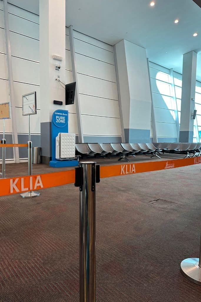 The AirAsia waiting area at Kuala Lumpur International Airport with a barrier to the seats.