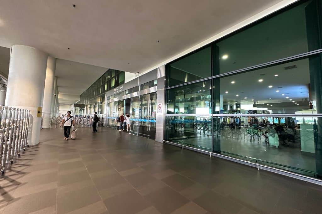 The Kuala Lumpur International Airport waiting area for the shuttle bus outside under the covered driveway.