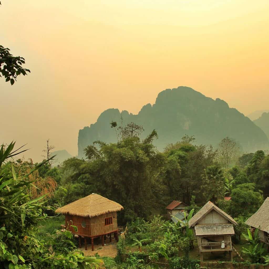 Village houses set on the top of the hill with the setting sun behind it.