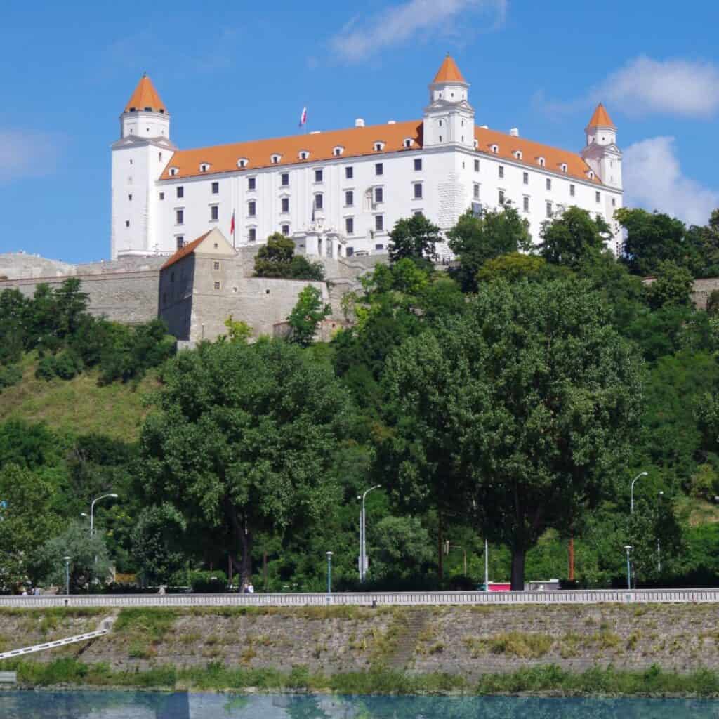 A White Castle sitting high above the landscape with trees in front of it.