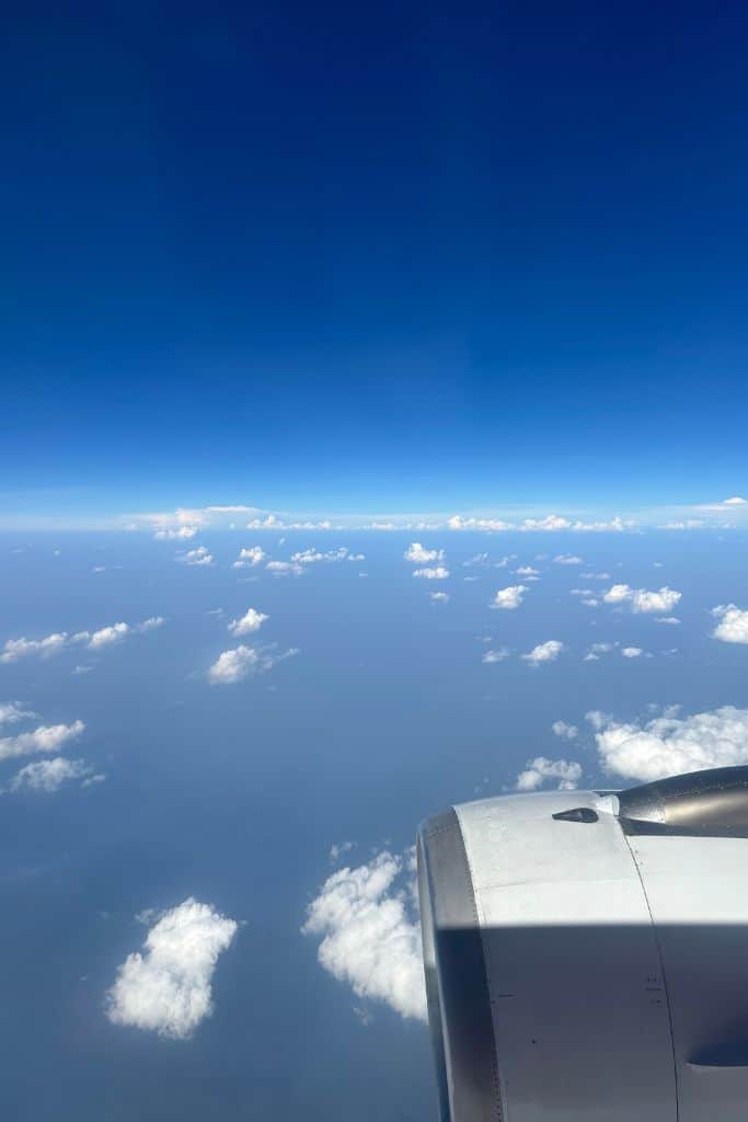 The sky showing clouds and blue sky from the window of the airplane.