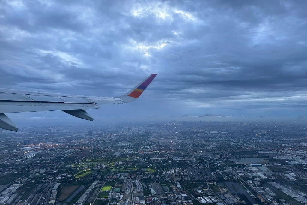 The tail of an airplane as it flies into Bangkok airport.