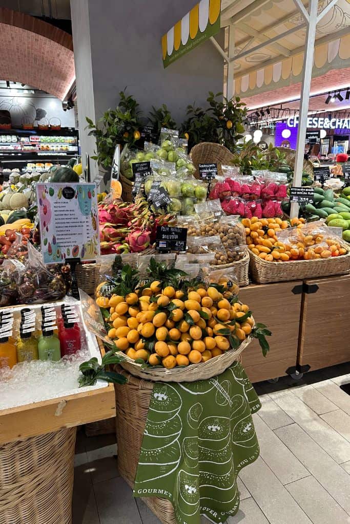 Baskets of vibrant fruit in the fruit section of the market on the ground floor of the mall in Bangkok.