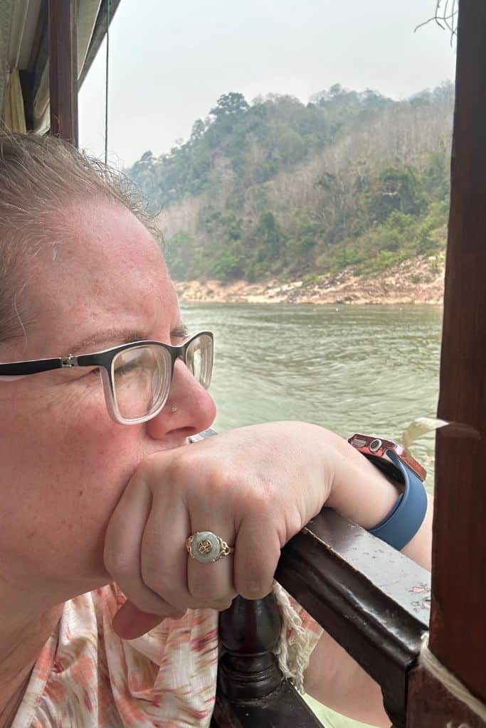 Me gazing pensively out the window of the slowboat and resting my arm on the side of the boat.