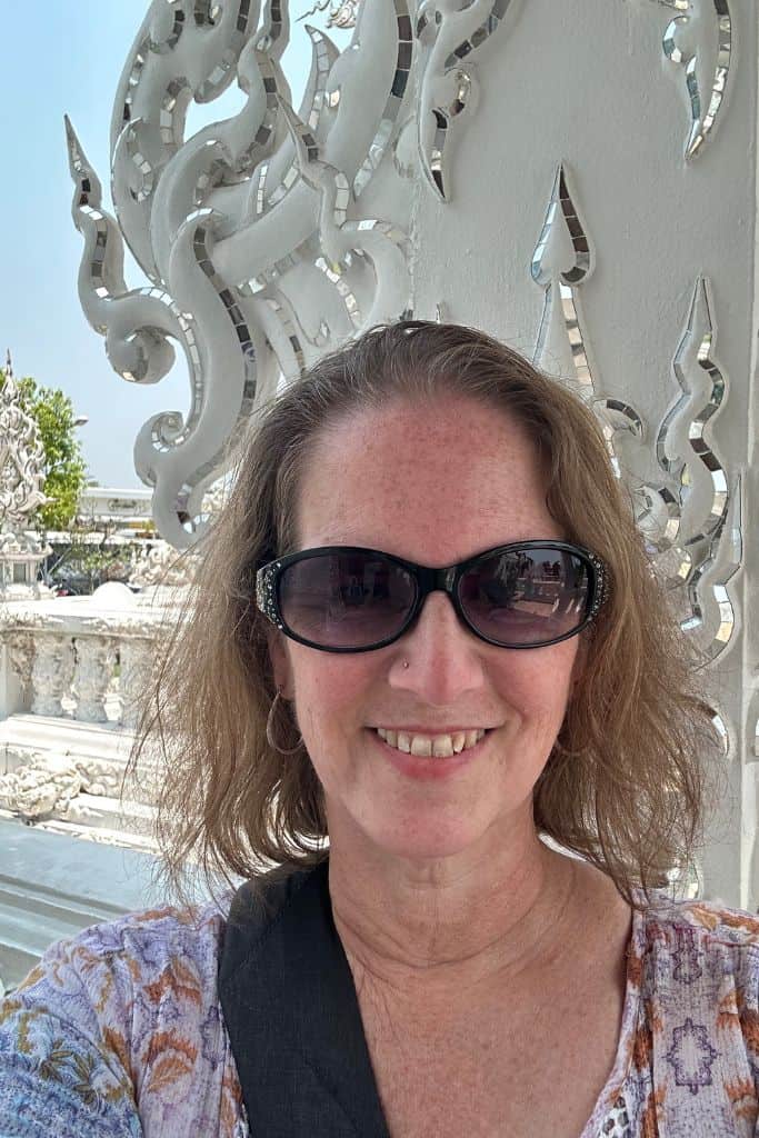 Me posing at the White Temple in Chiang Rai wearing sunglasses.