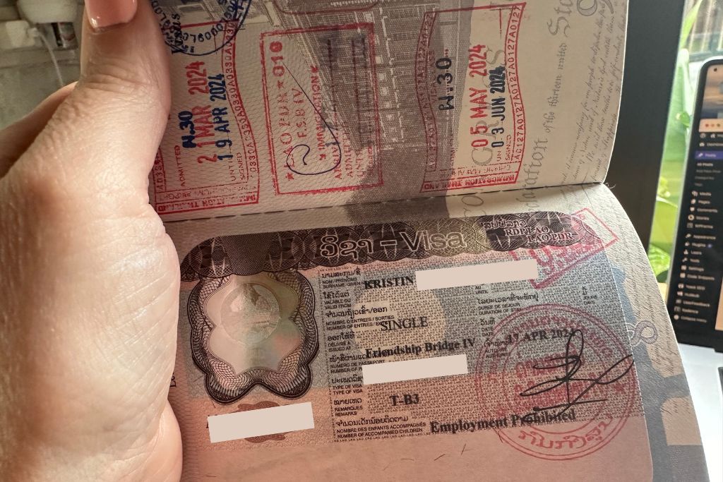 Showing my open passport with the stamps from Laos