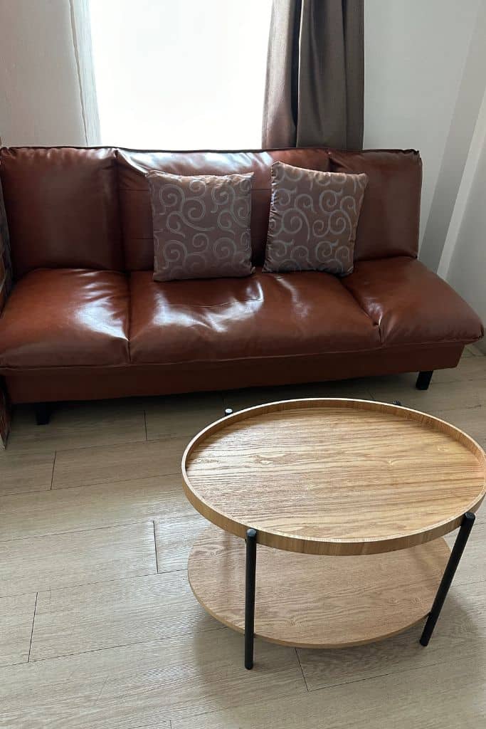 The leather couch and coffee table of my seating area.