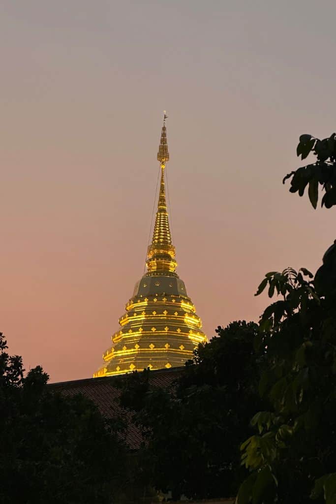 Doi Suthep's golden dome lit up against a pink sky