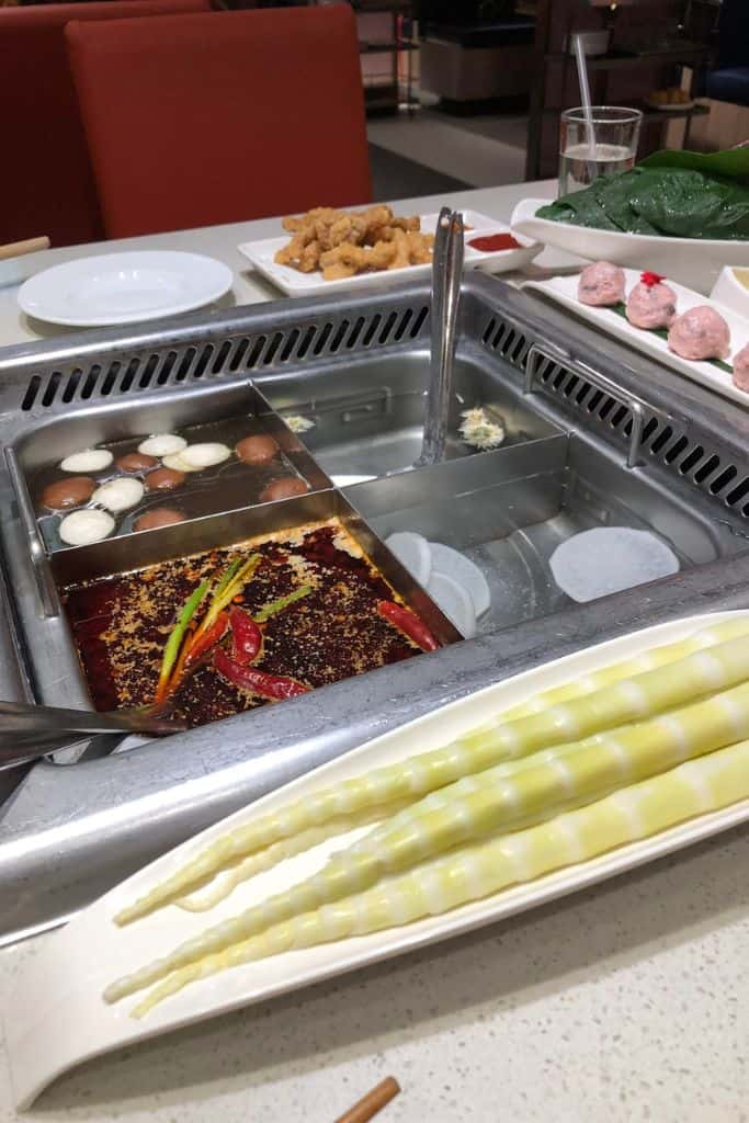 A hot pot restaurant with different heating sections for flavored broths to cook your food in.