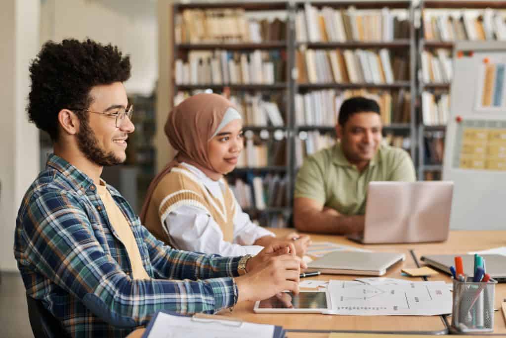 3 students sitting in a classroom.