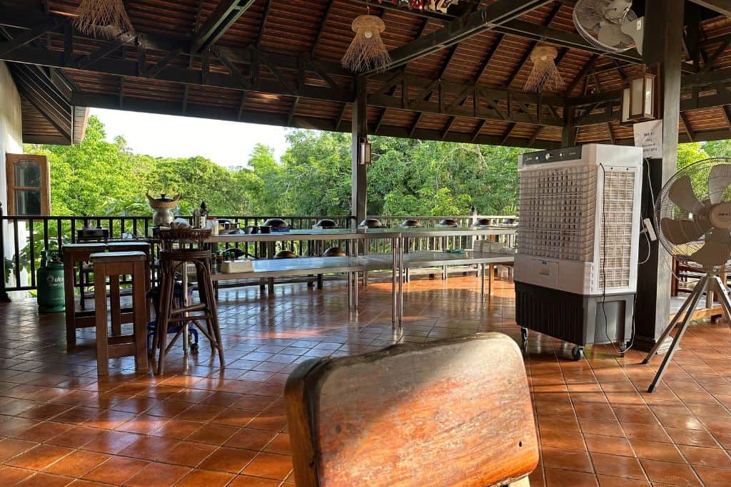 The open air setting of the cooking school with long stainless steel counters and prep areas.