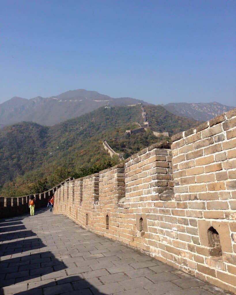 The stones of the Great Wall of China leading away toward a mountain in the background.