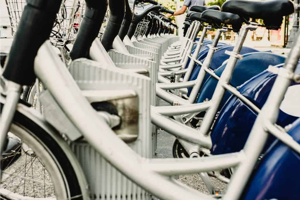 A line of white e-bikes on the street ready to be rented.